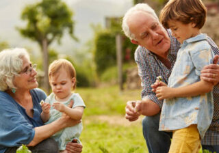 Grandparents talking to children. Family having leisure time in yard. They are wearing casuals.